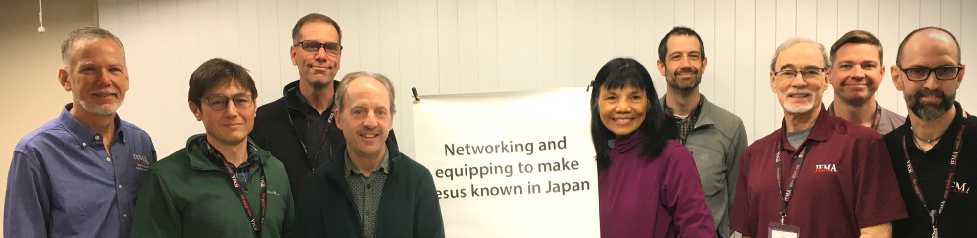 The JEMA Leadership Team holding a banner: networking and equipping to make Jesus known in Japan